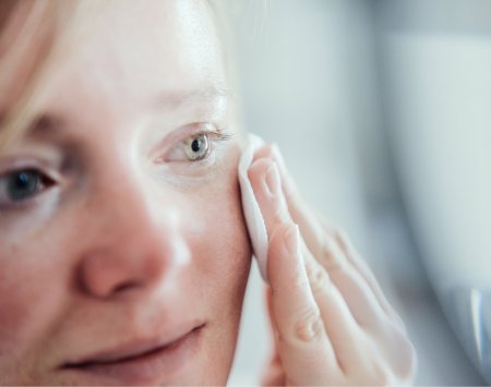 Une femme se passe un coton sur le visage